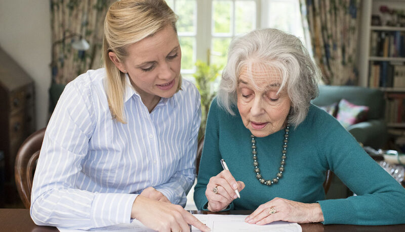 A Daughter Helping Her Senior Mother Fill Out Paperwork Purpose Of A Healthcare Power Of Attorney